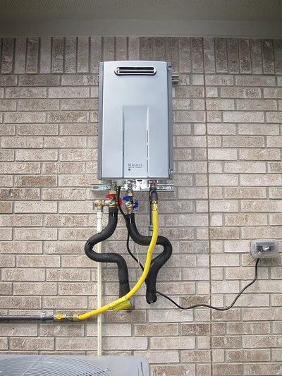Outdoor tankless water heater mounted on a brick wall